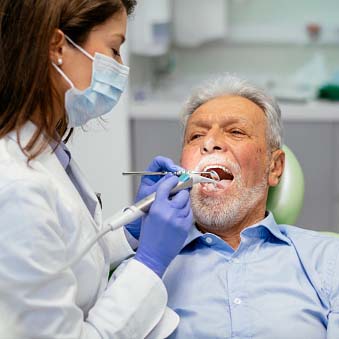 dental hygienist working on a man's teeth